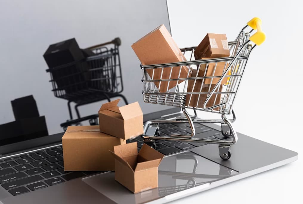 A shopping cart filled with boxes on a laptop keyboard, implying online shopping