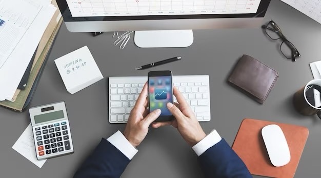 A man in a suit holds a smartphone in his hands, top view