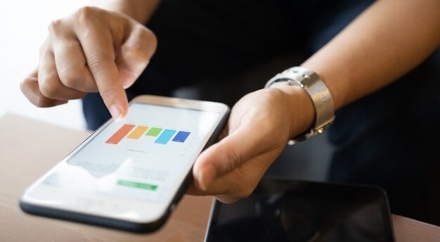 Man looking at graphs on his mobile phone