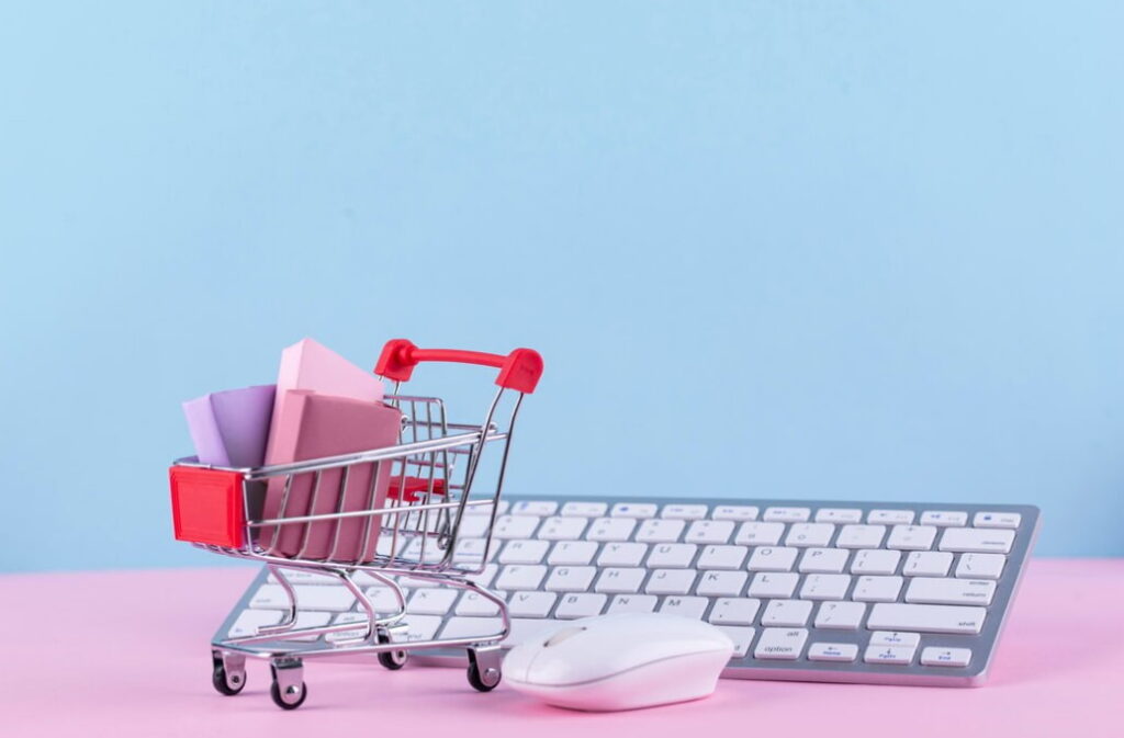 A tiny cart with gift boxes on a keyboard, depicting e-commerce