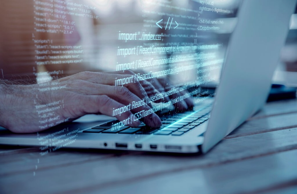 Hands typing on a laptop with code overlay graphics